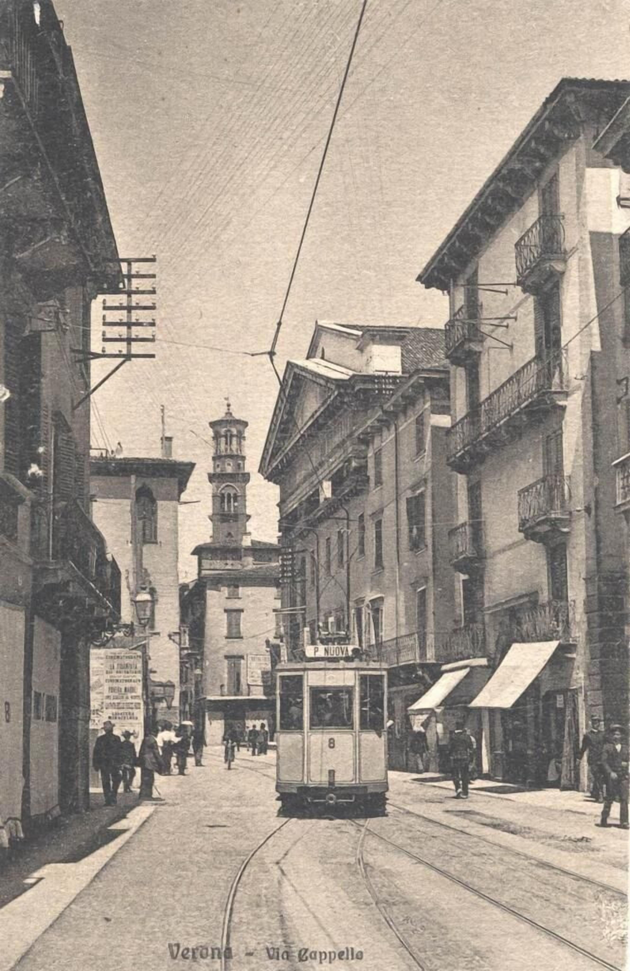 A vintage street scene with a tram, buildings, and a tower in the background.