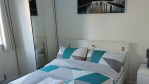 Une chambre à coucher avec un lit, une table de chevet, une armoire et un tableau au mur.