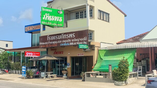 A hotel with a green sign, a blue sign, and a red sign.