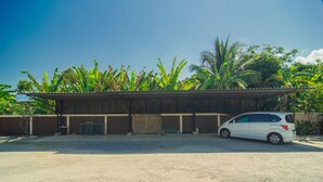 A building with a covered area and a parked car in front.