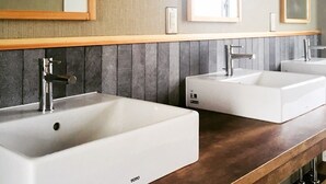 A modern bathroom with two white sinks, a wooden vanity, and large mirrors. - En Hostel Bar & Community Lounge (Kochi)