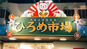 A storefront with a large sign featuring a cat and Japanese characters, indicating a market or shop. - En Hostel Bar & Community Lounge (Kochi)