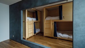 A room with two bunk beds, wooden flooring, and a dark wall. - En Hostel Bar & Community Lounge (Kochi)