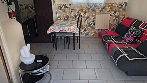 Un espace de vie compact comprenant un coin repas, un canapé et une petite table.