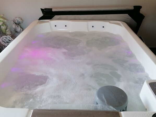 A hot tub with visible bubbles and a control panel.