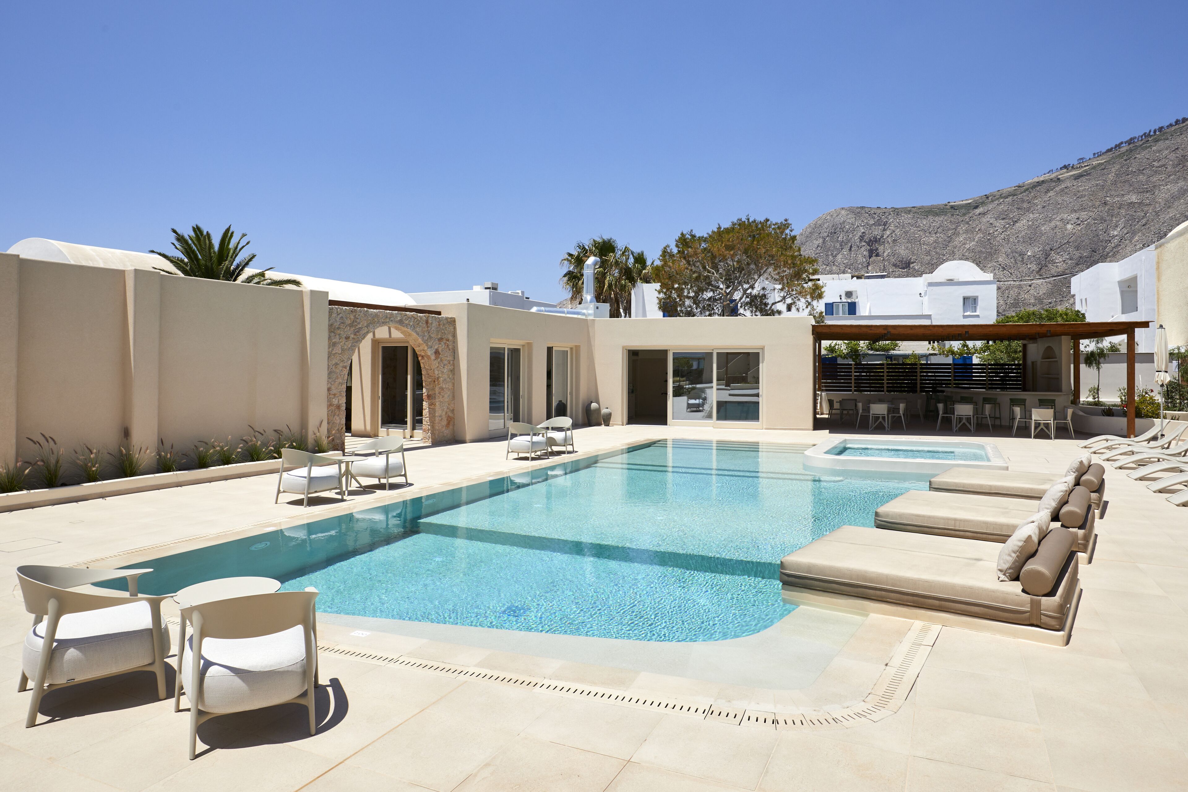 Uma área de piscina com espreguiçadeiras e um pérgola.