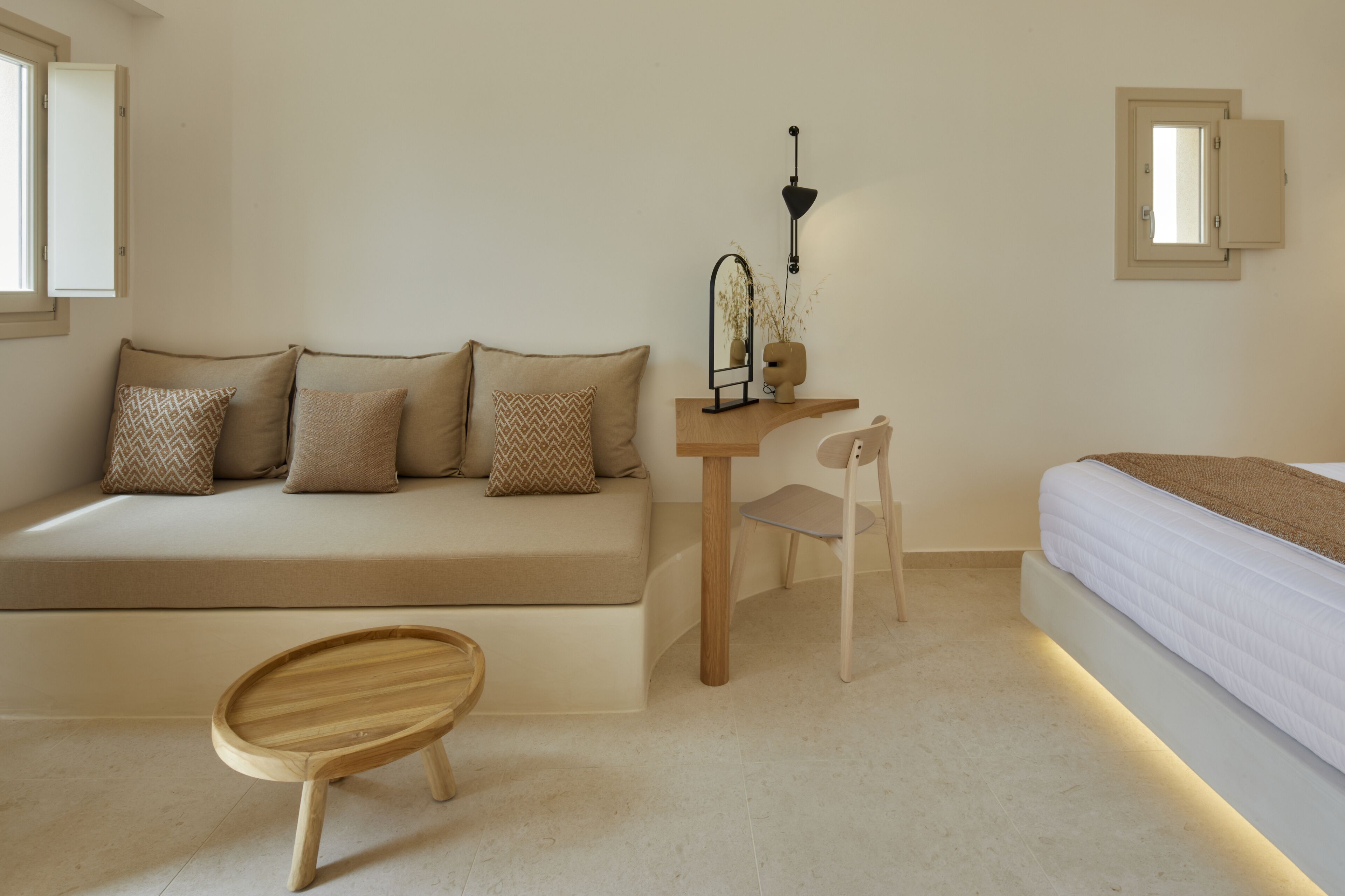 Un dormitorio minimalista con sofá, escritorio, silla y cama.