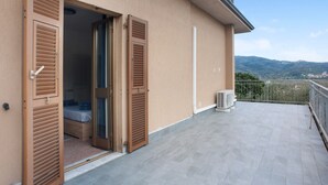A balcony with a bed, open shutters, and a view of the landscape. - Holiday Home 'Da Chicca' with Countryside View, Wi-Fi & Air Conditioning (Bolano)