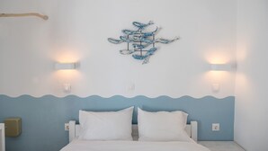 A bedroom with a bed, white pillows, a blue wavy wall design, and a wall-mounted light fixture. - Studio Apartment "Livadia Seaside 6" near Beach with Shared Terraces & Wi-Fi (Paros)