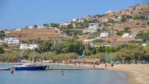 A coastal area with a beach, boats, and buildings on a hillside. - Studio Apartment 'Livadia Seaside Studios 8' with Shared Terrace, Wi-Fi & Air Conditioning (Paros)