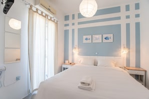 A hotel room with a bed, nightstands, a mirror, and a window with curtains.