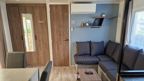 A compact living space with a sofa, a small table, a chair, and a window.