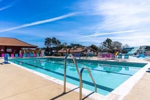A swimming pool with lounge chairs, a slide, and a clear sky. - 'Mobilehome Familial' with Shared Pool, Garden & Wi-Fi (Gastes)