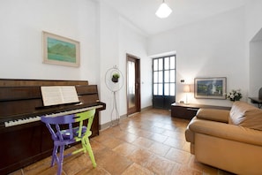 A piano, a chair, a couch, a door, and a window.