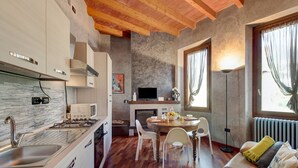 A modern kitchen with a built-in stove, white cabinets, and a herringbone wood floor. - Holiday Home 'Wakesurfhouse 2' with Lake View, Private Terrace and Wi-Fi (Sulzano)