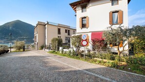 A cobblestone street with buildings, a mountain in the background, and a no parking sign. - Holiday Home 'Wakesurfhouse 2' with Lake View, Private Terrace and Wi-Fi (Sulzano)
