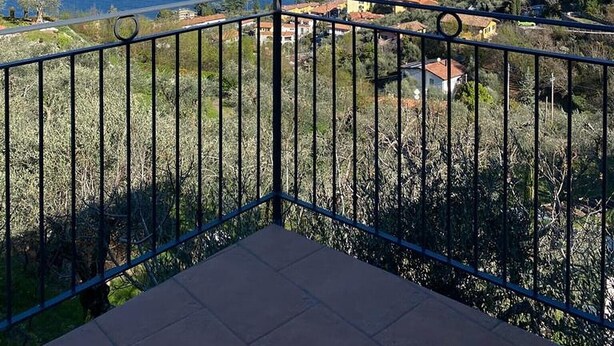 A balcony with a view of a coastal landscape, including mountains and a body of water. - Apartment 'Olive Grove House' with Lake View, Private Terrace and Shared Garden (Malcesine)