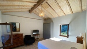 A bedroom with a bed, dresser, TV, and a window with a view. - Apartment 'Olive Grove House' with Lake View, Private Terrace and Shared Garden (Malcesine)