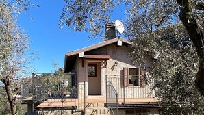 A stone house with a sloped roof, a small porch, and a satellite dish. - Apartment 'Olive Grove House' with Lake View, Private Terrace and Shared Garden (Malcesine)