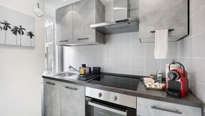 Eine moderne Küche mit Einbauofen, Kochfeld und einem roten Wasserkocher.