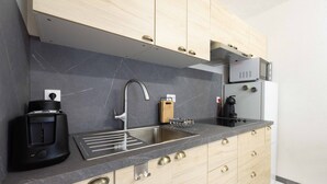 Une cuisine moderne équipée d’un four à micro-ondes encastré, d’une machine à café et d’un évier.