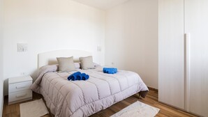 A bedroom with a bed, a nightstand, a wardrobe, and a small rug. - Holiday Home "Casa Jerzu S'essia de su santu" with Sea View, Garden & Wi-Fi (Jerzu)