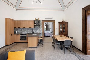 Une cuisine moderne avec des meubles en bois, un îlot central et un coin repas comprenant une table et des chaises en bois.