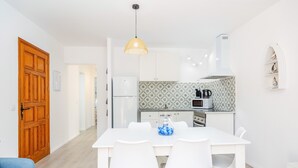 Une cuisine moderne avec des armoires blanches, un four à micro-ondes et un revêtement mural décoratif.