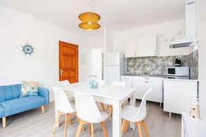 A compact kitchen with white cabinets, a microwave, and a coffee maker.