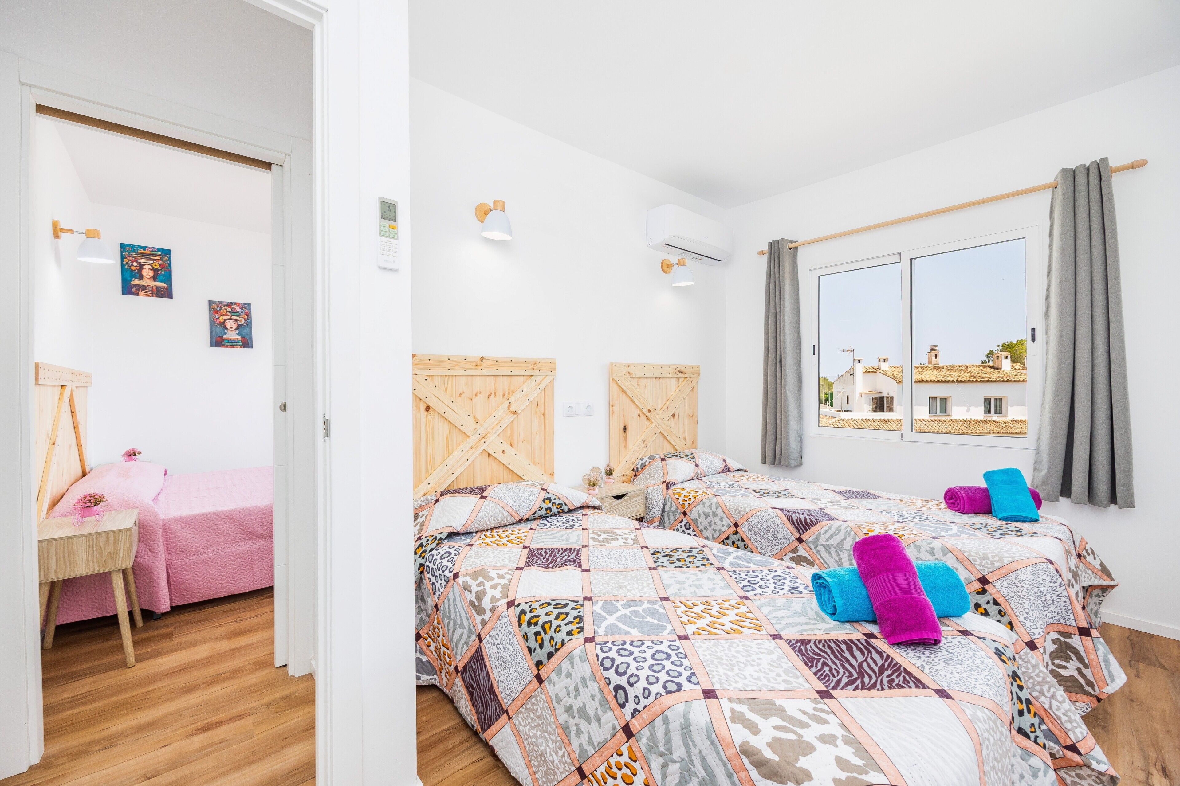 Un dormitorio con dos camas, un escritorio y una ventana con vistas.
