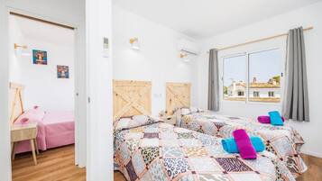 Un dormitorio con dos camas, un escritorio y una ventana con vistas.