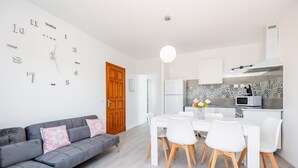 Een moderne keuken met witte kasten, een magnetron en een decoratieve spatwand.