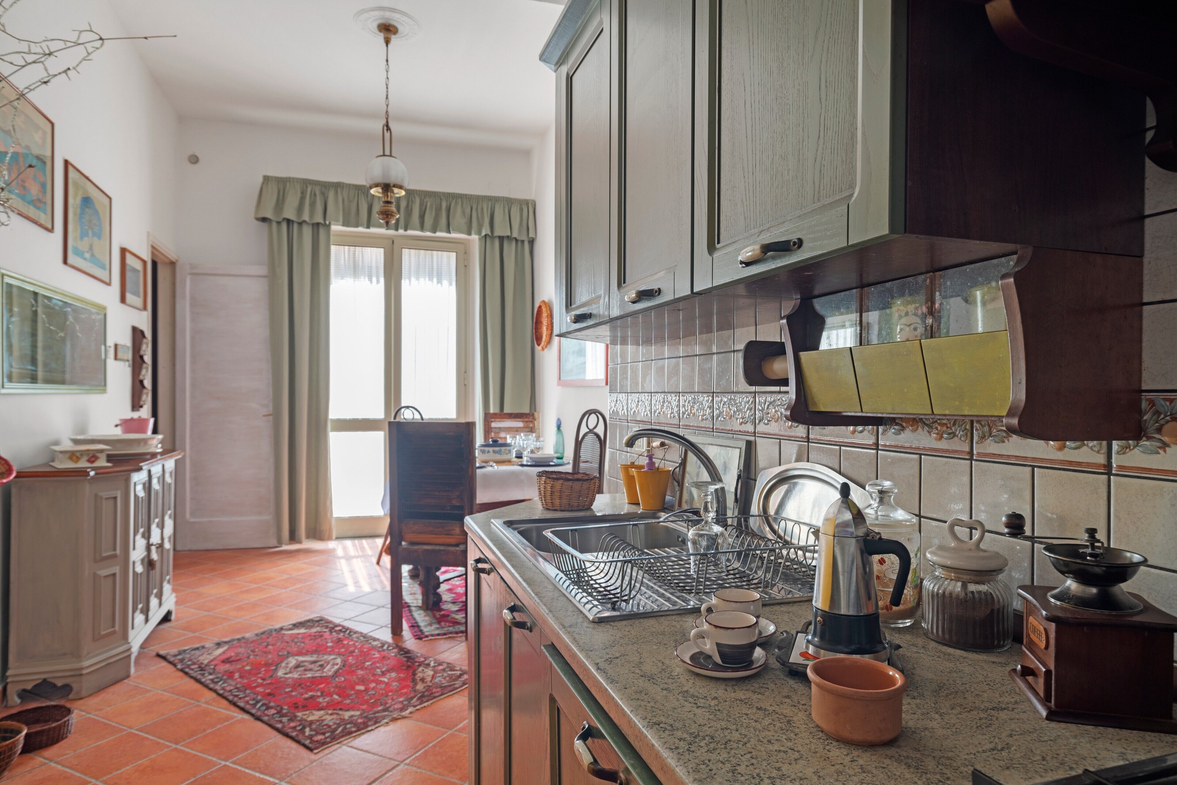 Una cucina con lavello, macchina del caffè e piano cottura.
