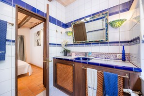 A bathroom with a wooden cabinet, a sink, a mirror, and a towel rack.