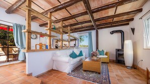 A cozy living room with a white sofa, a wicker side table, a large vase, and a fireplace. - Vacation Apartment "Individual Guesthouse Mallorca" with Mountain Views, Pool & Wi-Fi (Manacor)