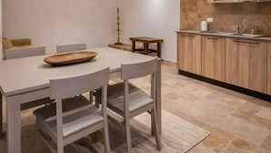 Una cocina moderna con techo de piedra, armarios de madera y una zona de comedor con mesa y sillas.