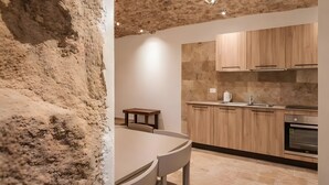 Una cocina moderna con armarios de madera, una mesa redonda y una pared de piedra.