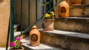 Terracotta pots on stone steps, a green metal railing, and a small potted plant with pink flowers. - Apartment “Junior Suite Adults Only Mallorca” with Mountain View, Shared Pool & Wi-Fi (Manacor)