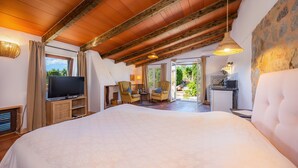 A spacious bedroom with a large bed, a television, and a view of the outdoors. - Apartment “Junior Suite Adults Only Mallorca” with Mountain View, Shared Pool & Wi-Fi (Manacor)