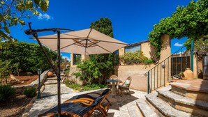 A patio with outdoor furniture, a table, and a large umbrella. - Apartment “Junior Suite Adults Only Mallorca” with Mountain View, Shared Pool & Wi-Fi (Manacor)