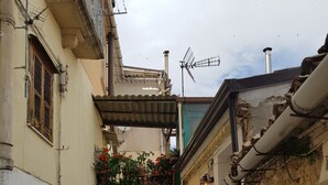A narrow alleyway with buildings on either side, a staircase leading to a higher level, and a balcony with flowers. - Apartment 'Cafuorchie - Arco Pronti' with Mountain View, Wi-Fi and Air Conditioning (Sant'Agata di Puglia)