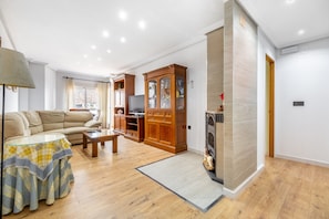 A living room with a sofa, a coffee table, a TV, and wooden cabinets. - Apartment 'La Gimena ' with Balcony and Air Conditioning (Orihuela)