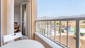Un balcon avec vue sur un parking et les montagnes.