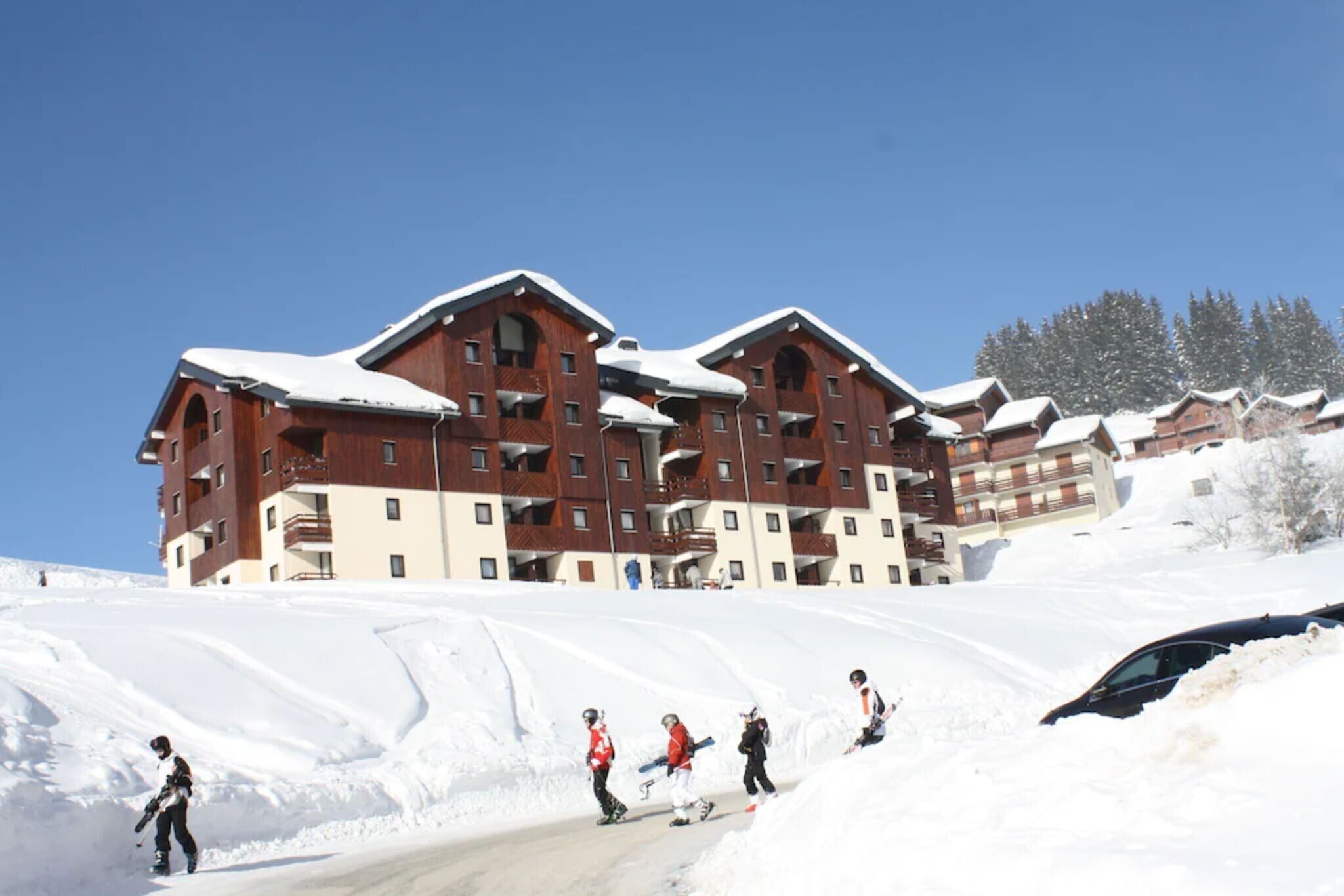 Een meerhoog hotel met een skipiste op de voorgrond.