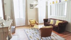 En stue med en brun sofa, en gul lænestol, et lille bord og en lampe.