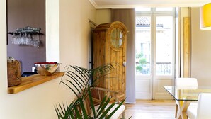 A room with a wooden door, a glass table, and a plant.