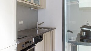 A modern kitchen with a built-in oven, a sink, and a coffee maker. - Belfort - 2 chambres / Avec ascenseur et Parking (Burdeos)