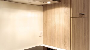 A kitchen with a modern design, featuring a stainless steel range hood, wooden cabinets, and a white countertop. - Condillac - Localisation exceptionnelle avec ascen (Burdeos)