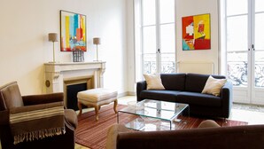A living room with a fireplace, a sofa, a coffee table, and two paintings on the wall. - Condillac - Localisation exceptionnelle avec ascen (Burdeos)