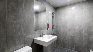 Een moderne badkamer met een witte wastafel, een spiegel en een douche.